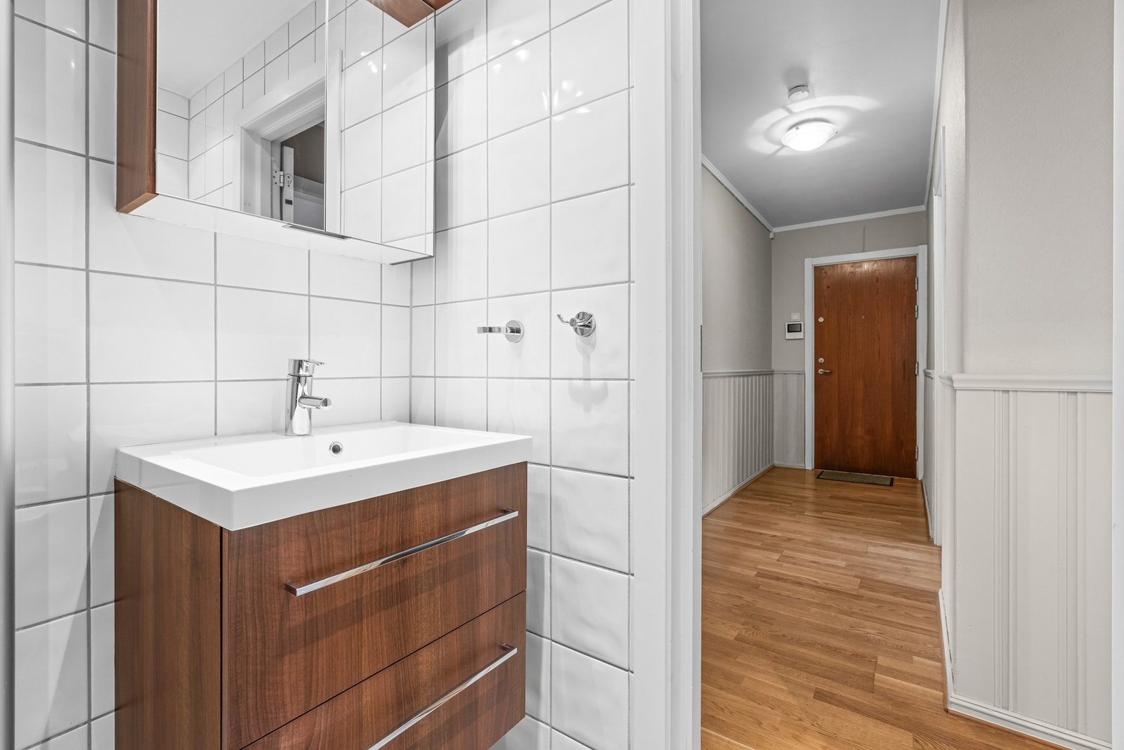 Videre har badet heldekkende servant på en skuffeseksjon og et overskap med to speildører og lyslist. Galleribilde