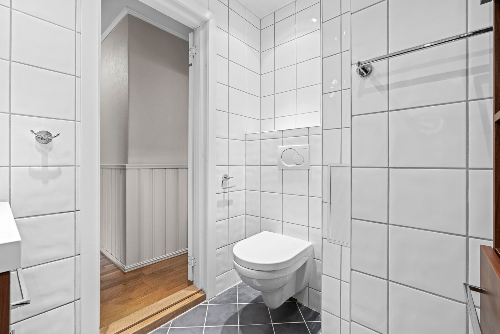 Her er det hvite fliser på veggene og grå fliser på gulv med gulvvarme. Galleribilde