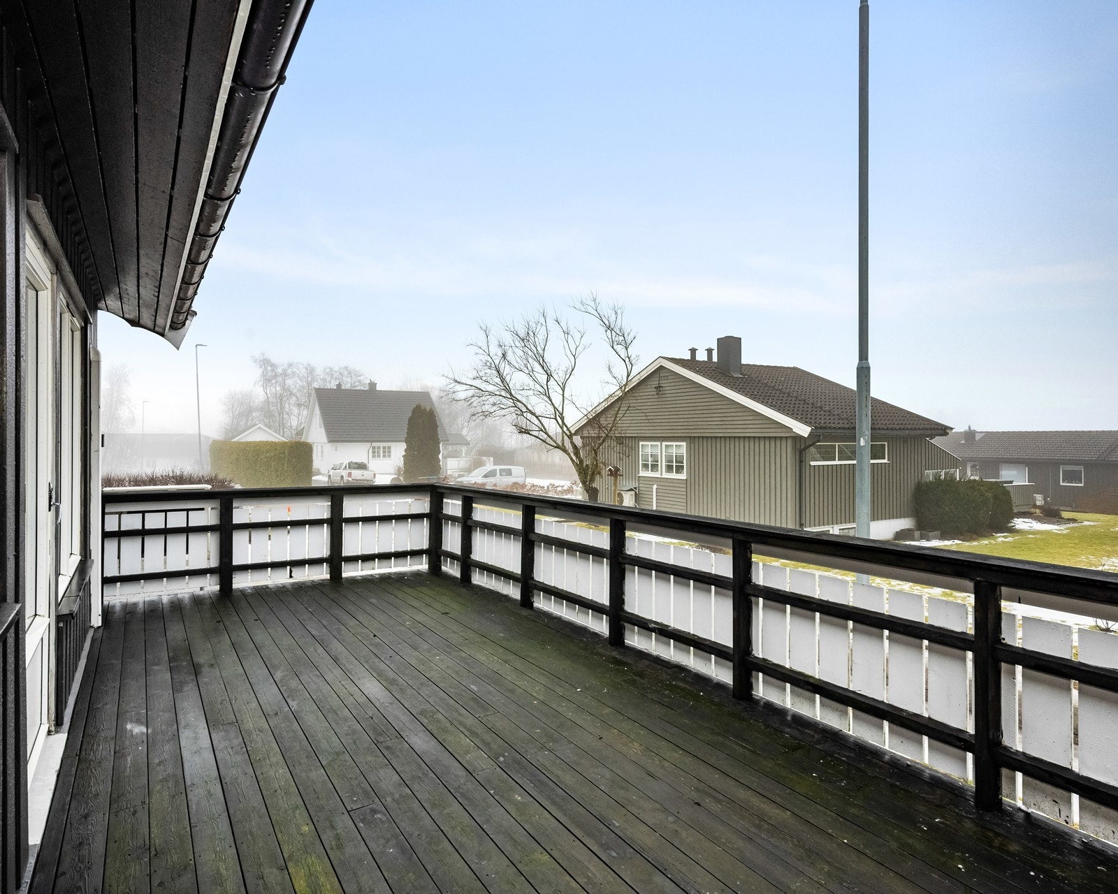 Verandaen i treverk på 21 m² gir god plass til utemøbler og har levegg for skjerming. Galleribilde