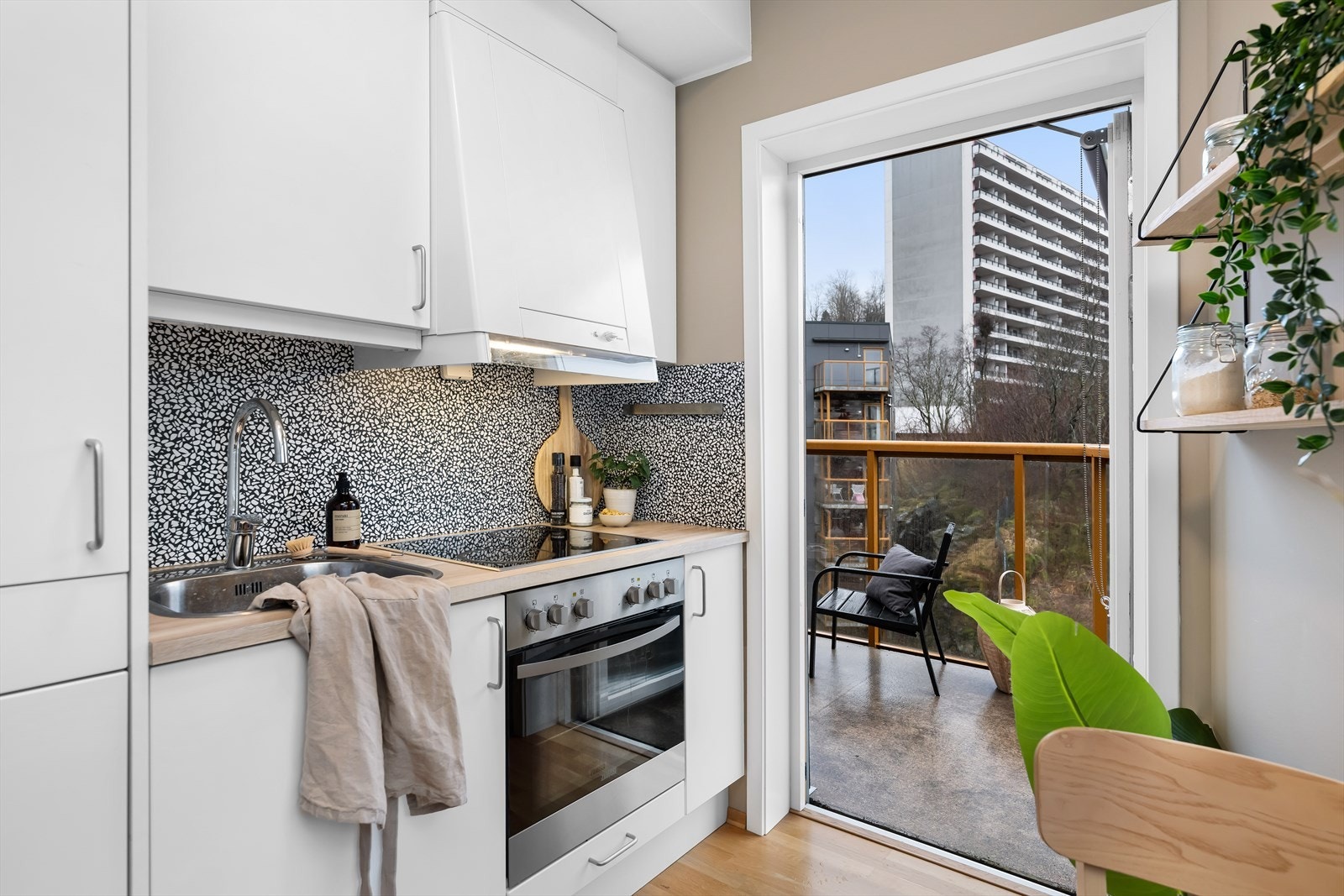 Fin kjøkkeninnredning med slette fronter og laminat benkeplate med nedfelt vask. Galleribilde