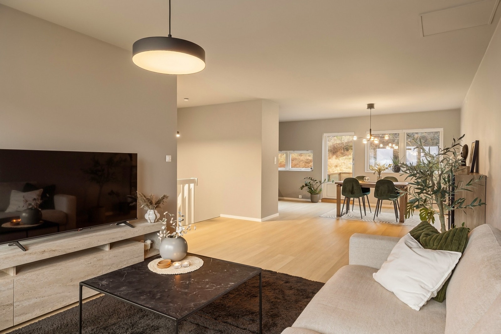 Delvis åpen stue- og kjøkkenløsning setter et sosialt preg på boligen Galleribilde