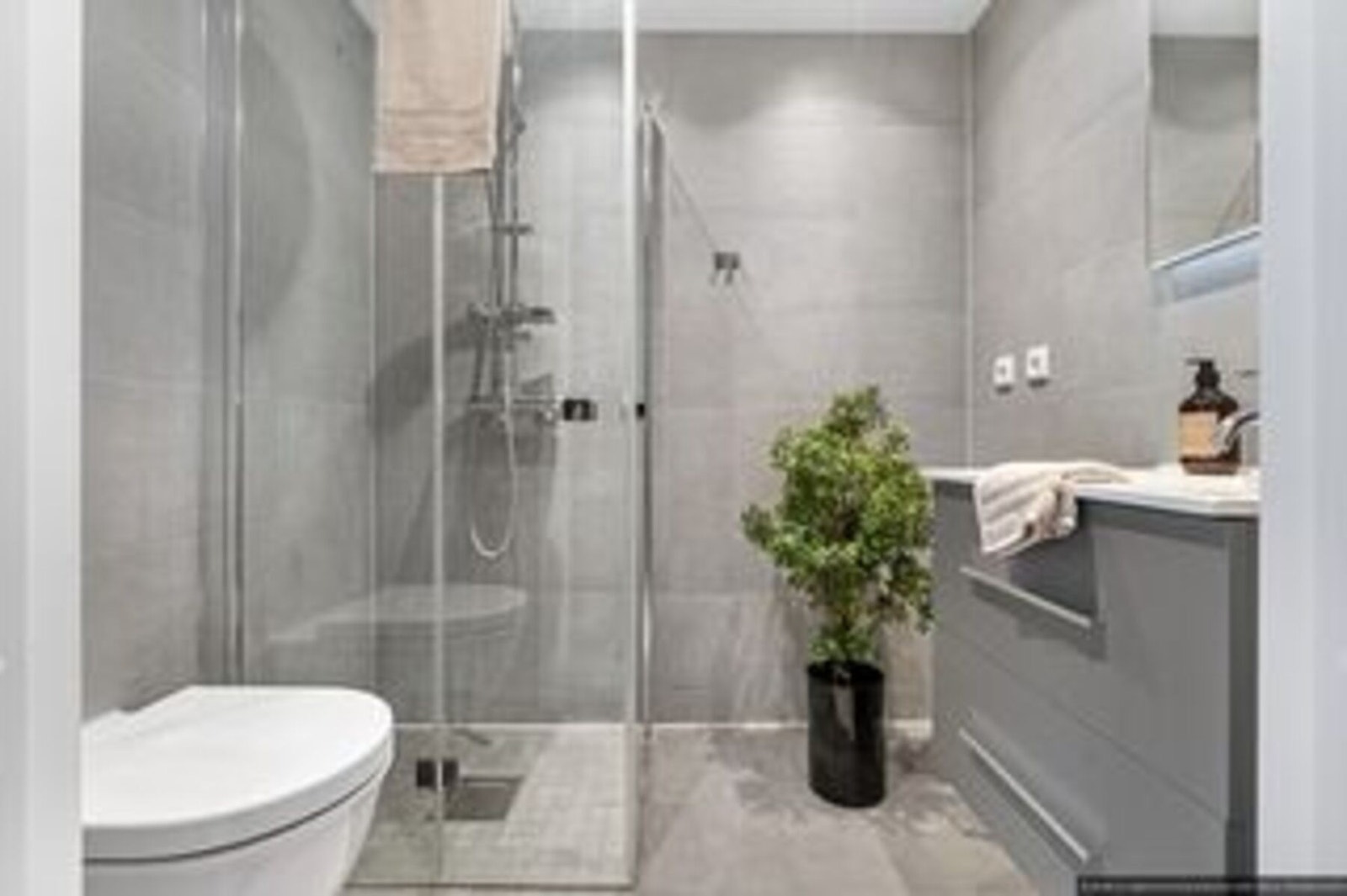 Delikat, flislagt baderom med varmekabler, downlights i himling og opplegg for vaskemaskin. (illustrasjonsbilde hentet fra tilsvarende leilighet med hybeldel) Galleribilde