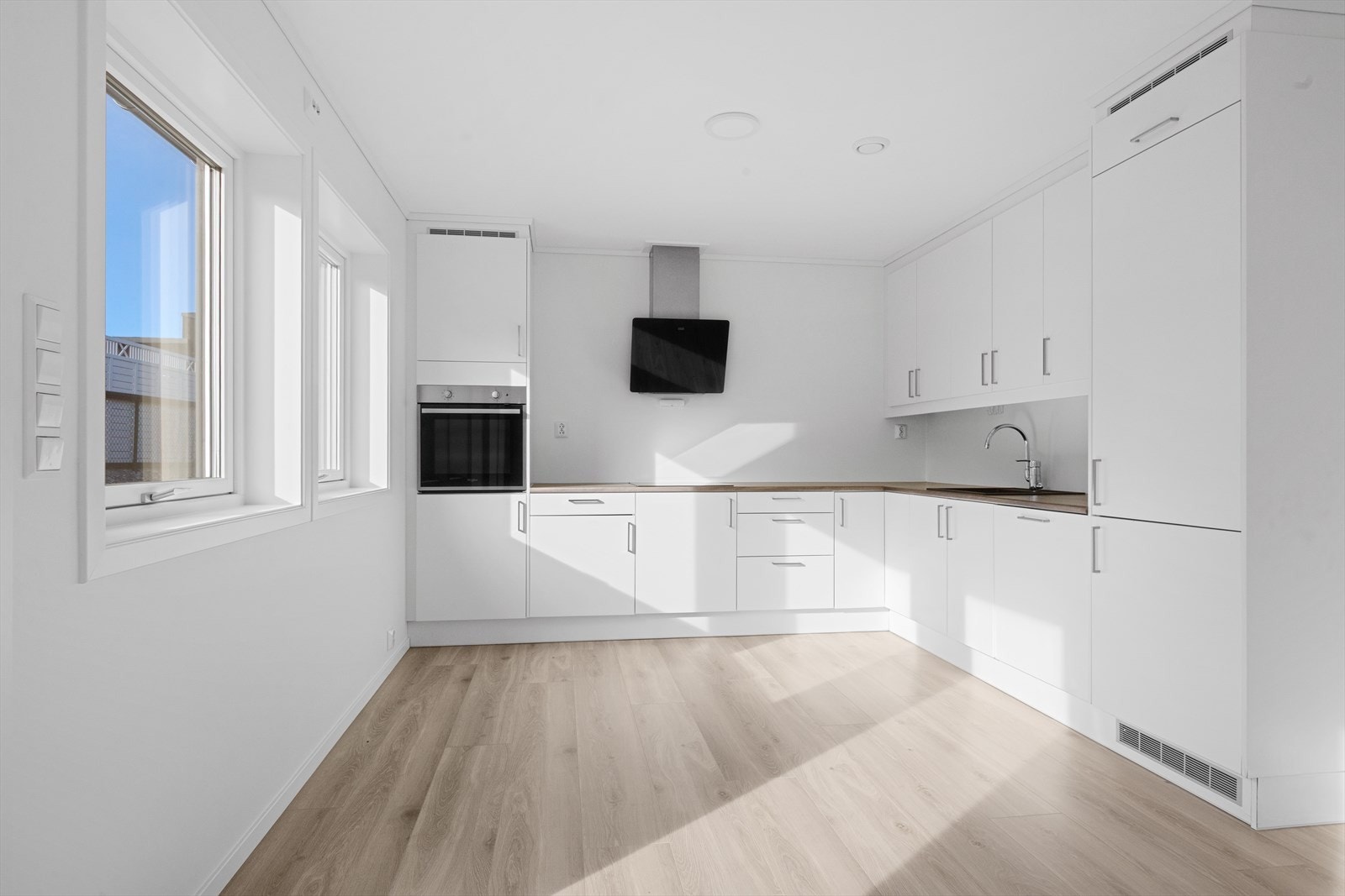 Kjøkken med enstavs laminatgulv og malte gipsvegger. Kjøkkeninnredning fra Mesterkjøkken med integrerte hvitevarer fra Whirlpool. Kjøkkenventilator fra Franke. Kjøkkenservant i kompositt. Komfyrvakt og automatisk vannstoppekran Galleribilde