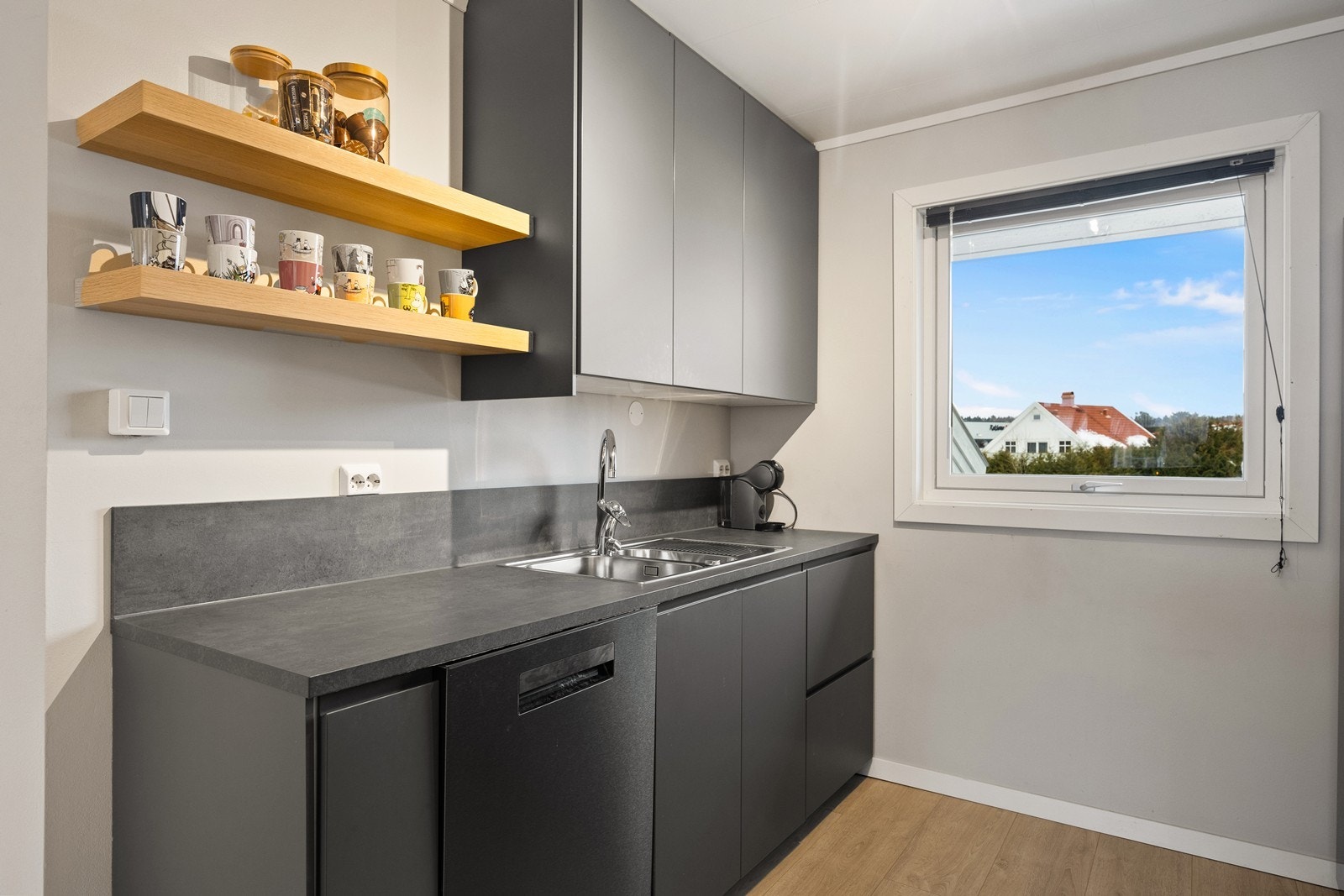 Praktisk kjøkkensone med vask, integrert oppvaskmaskin og gode oppbevaringsløsninger. Vinduet slipper inn rikelig med naturlig lys og gir en luftig romfølelse. Galleribilde