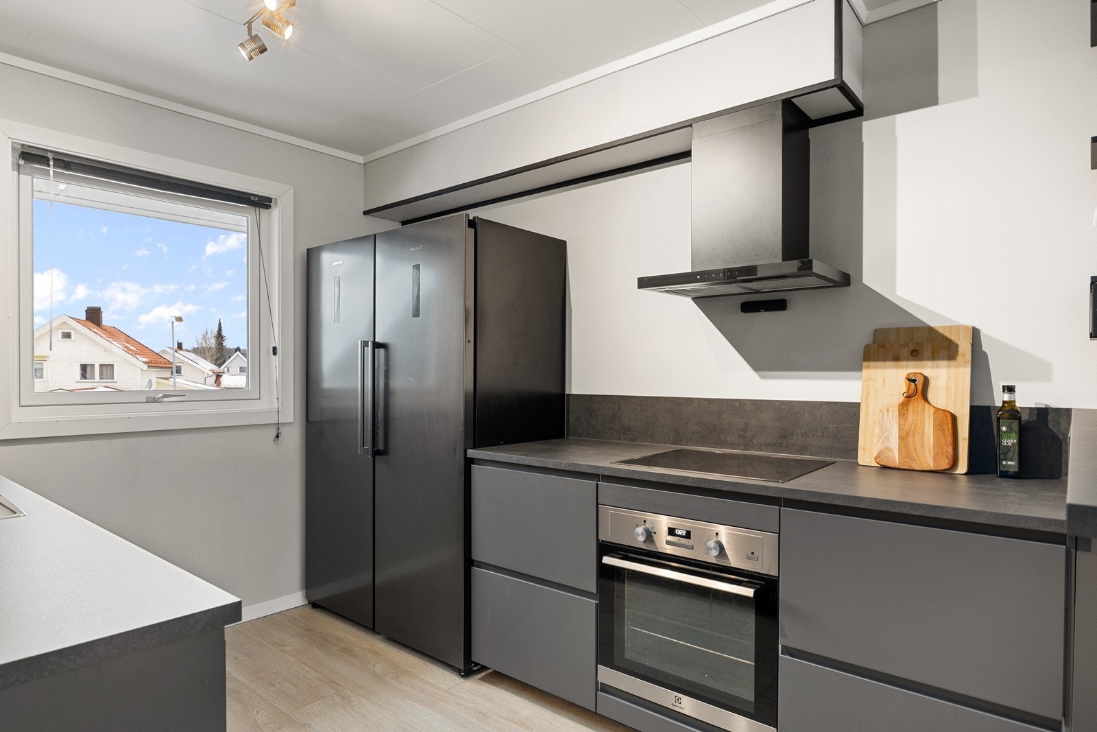 De mørke frontene og integrerte hvitevarene skaper et eksklusivt preg, mens den gjennomtenkte løsningen gjør kjøkkenet like godt egnet for hverdagsmiddager som sosiale sammenkomster. Galleribilde