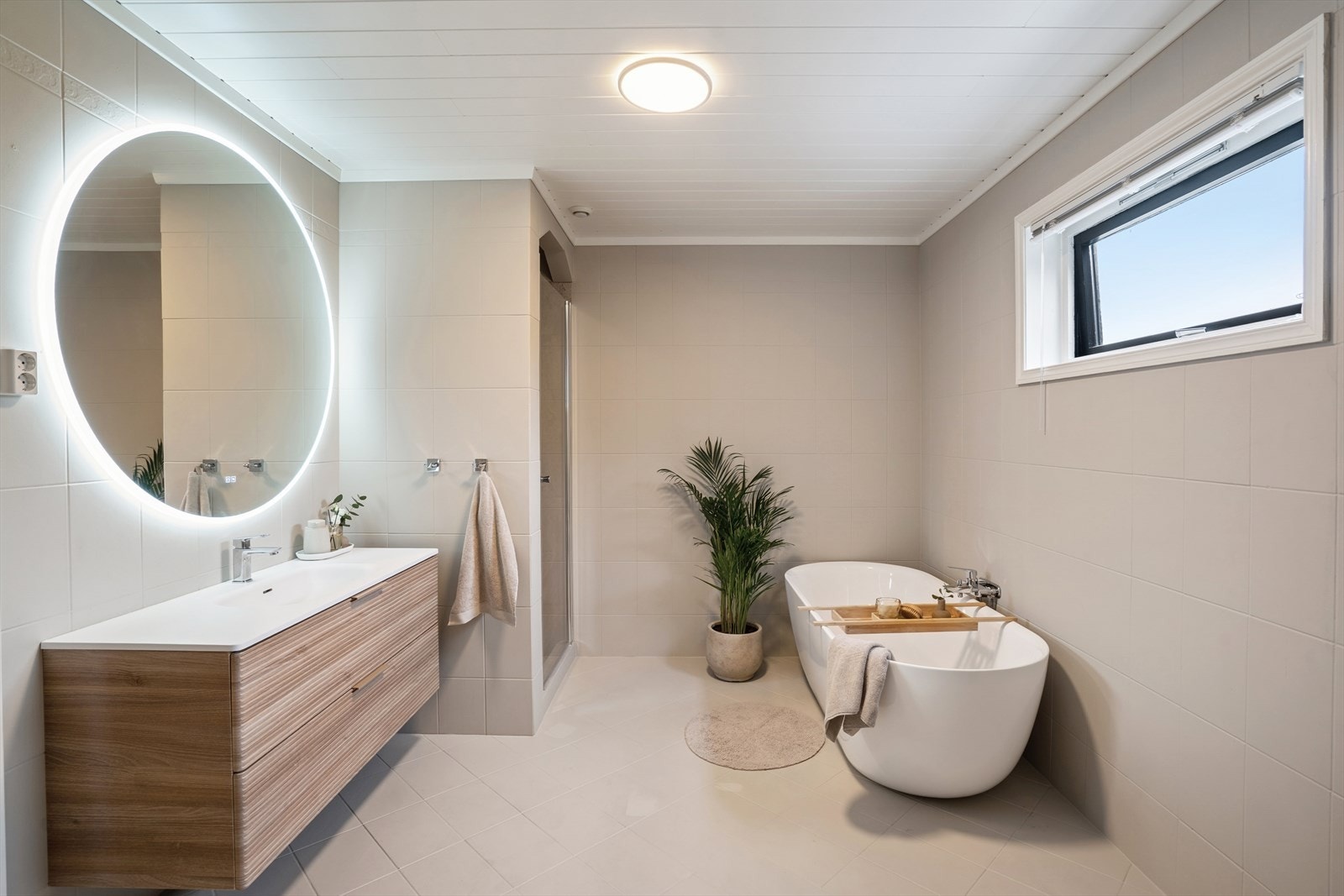 Badet i 1.etasje er innredet med dusj, toalett, en innredning med to servanter og et badekar. Galleribilde