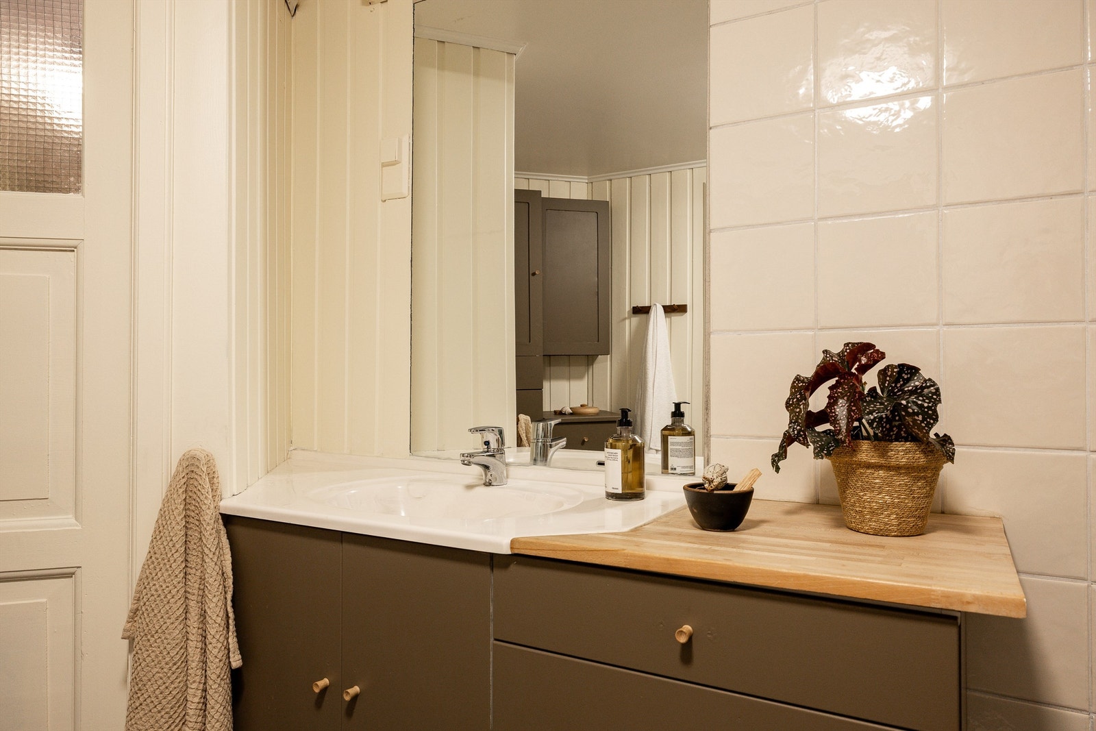 Badet er innredet med servant m/servantskuffer- og skap, gulvstående toalett, dusjhjørne med glassvegger og opplegg for vaskemaskin. Galleribilde