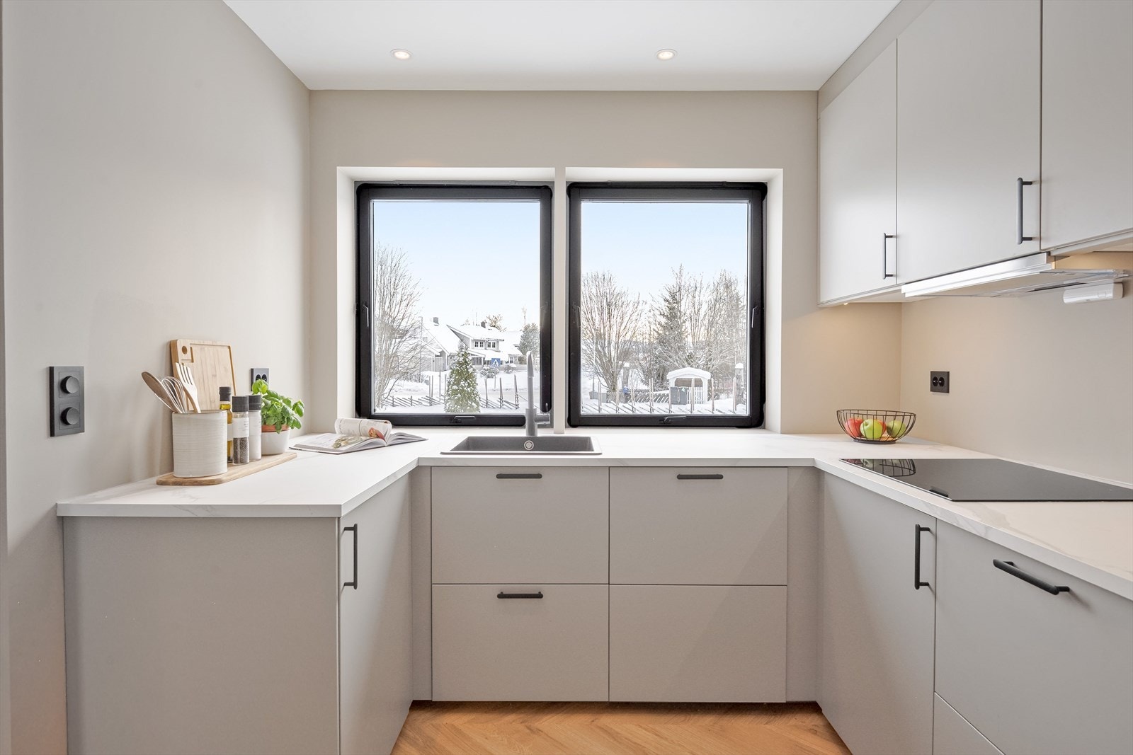 Over kjøkkenbenken er det to store vindusflater som slipper inn naturlig arbeidslys. Det er også downlights i himlingen. Galleribilde