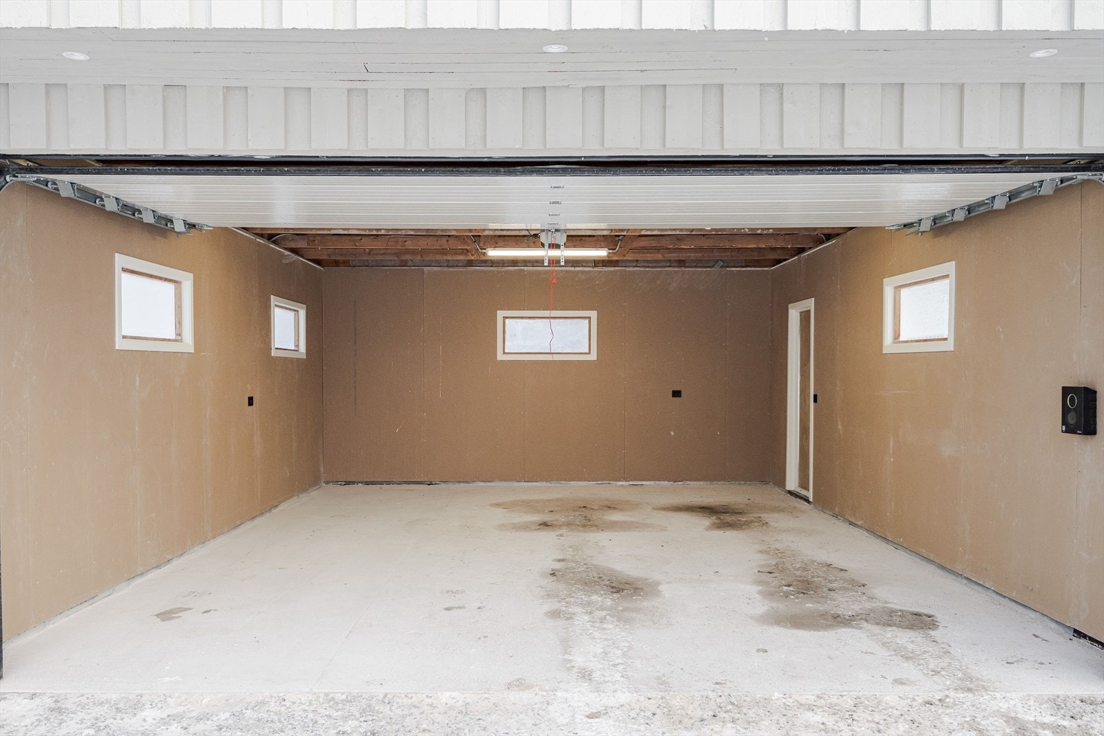 Garasjen er oppgradert i 2025 med bla. ny støpt plate, nye gipsplater på veggene, ny leddport med motorstyring og ny elbil-lader. Galleribilde