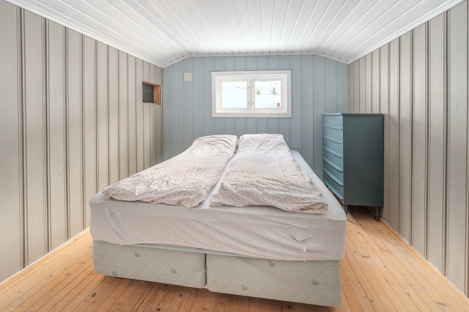 Panelvegger og tregulv gir et naturlig preg til soverommet. Galleribilde