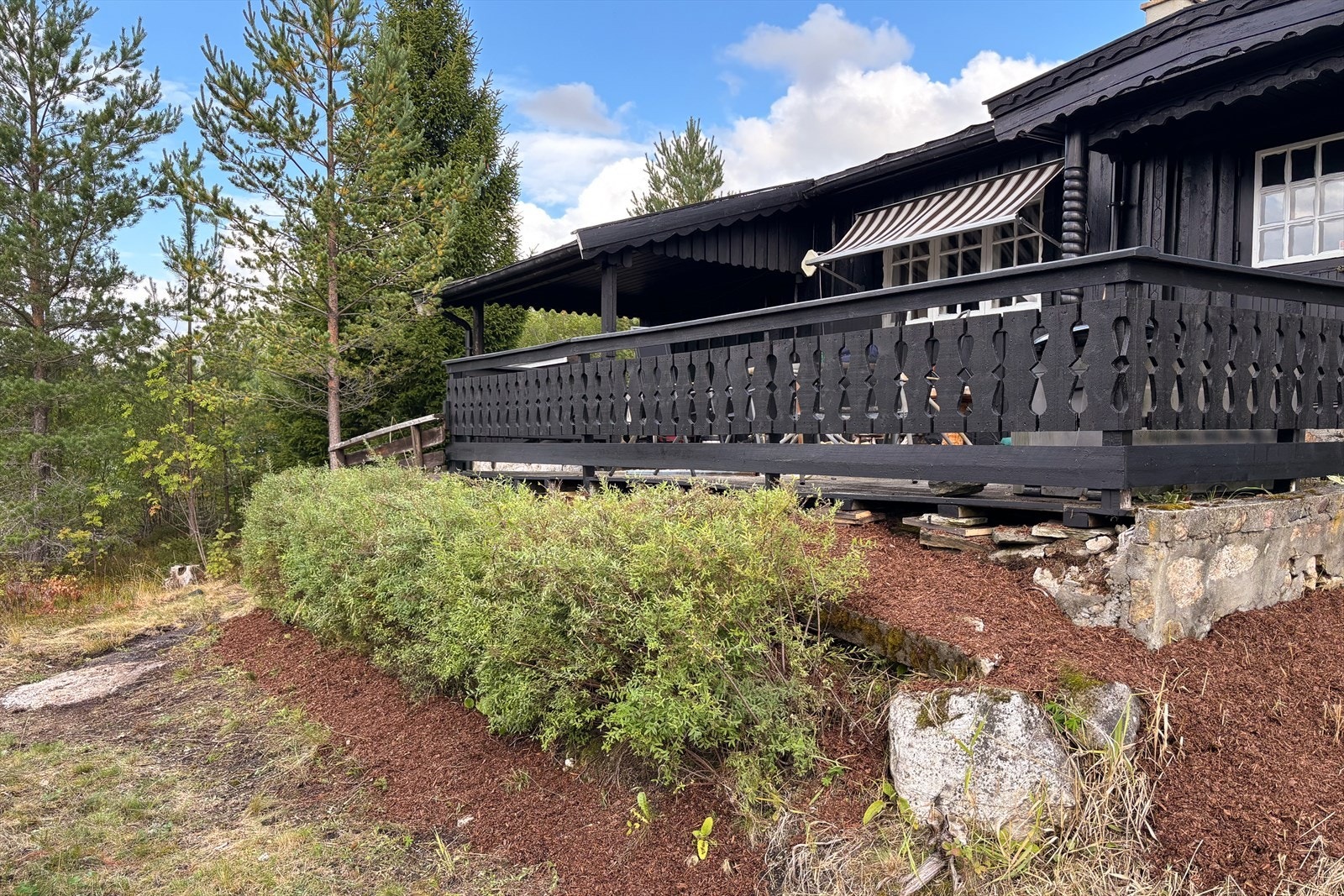 Terrassen er bygget med dekorative rekkverk og har en steinmur som fundament. Galleribilde