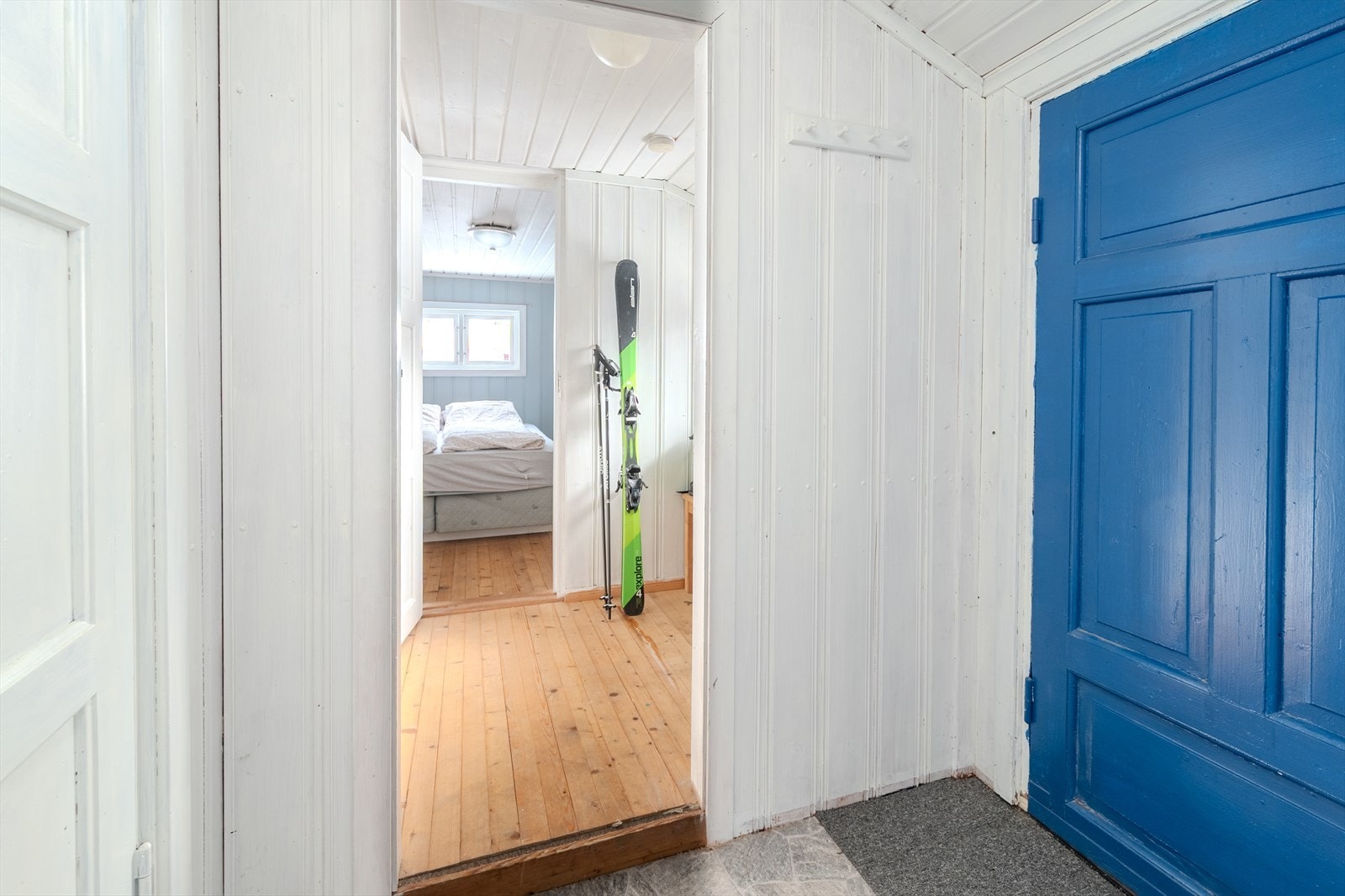 Lyse vegger og beleg/teppeflis og tregulv gir en tradisjonell hyttefølelse i entréen. Galleribilde