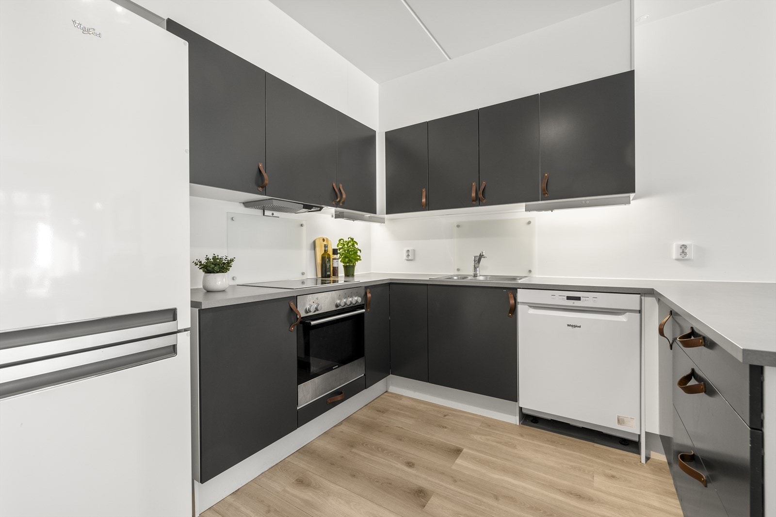 Kjøkkeninnredningen fra 2016 har mørke, glatte fronter og integrert komfyr, platetopp og oppvaskmaskin. Galleribilde