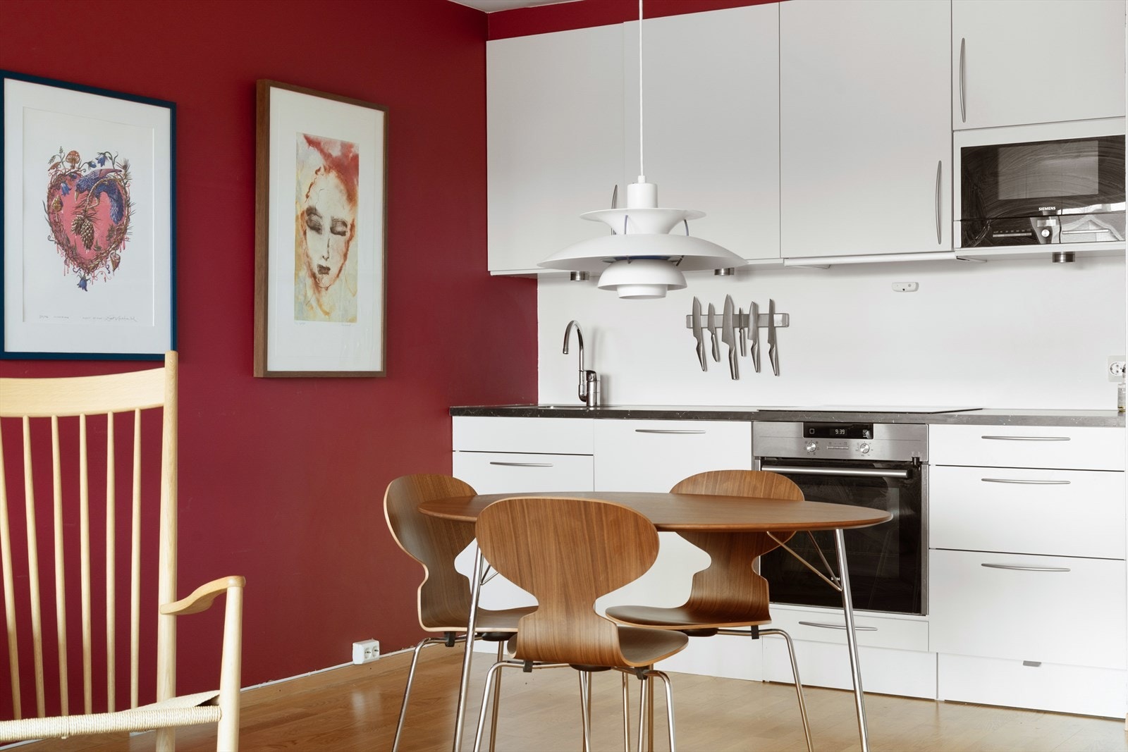 Hvitt kjøkken med integrerte hvitevarer som steketopp, oppvaskmaskin, komfyr og micro. Galleribilde