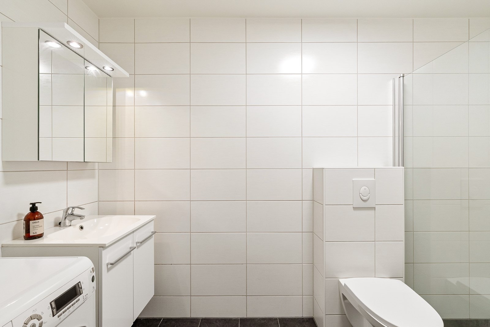 Flislagt baderom med vask i skapseksjon. Galleribilde