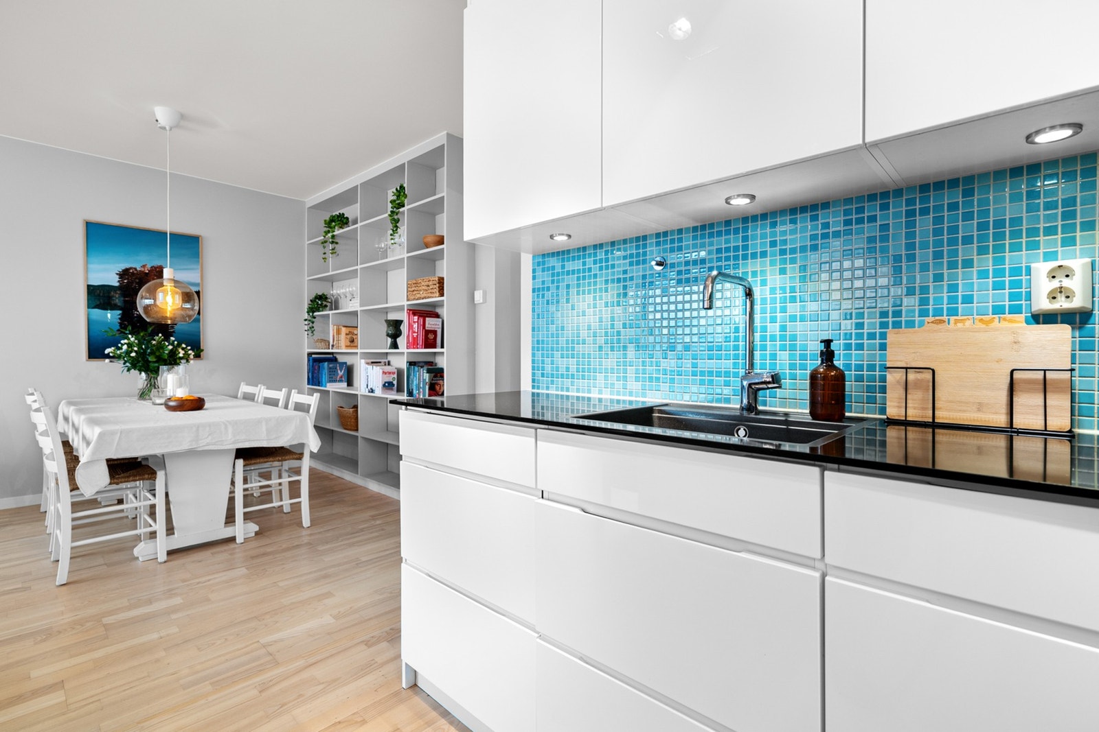 Over benkeplaten er det lagt mosaikkfliser i en blå tone som skaper en fin kontrast til de lyse flatene. Galleribilde