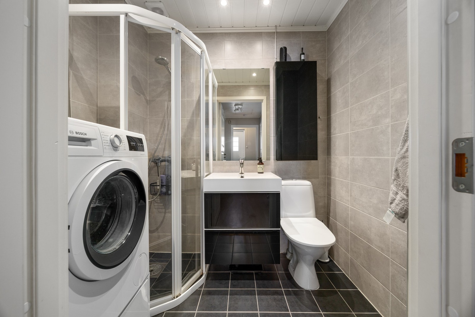 Bad/vaskerom - ca. 3 kvm. Pent flislagt bad, opplyst oppusset i 2013. Utstyrt med bl.a. gulvvarme, dusjhjørne, WC, servantskap og opplegg for vaskemaskin. Galleribilde