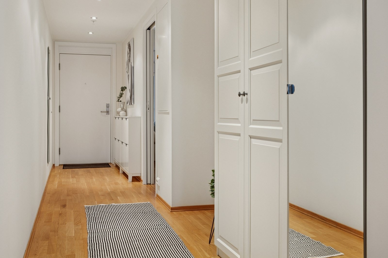 Romslig og innbydende entre/gang med dørtelefon og downlights i himling. Galleribilde