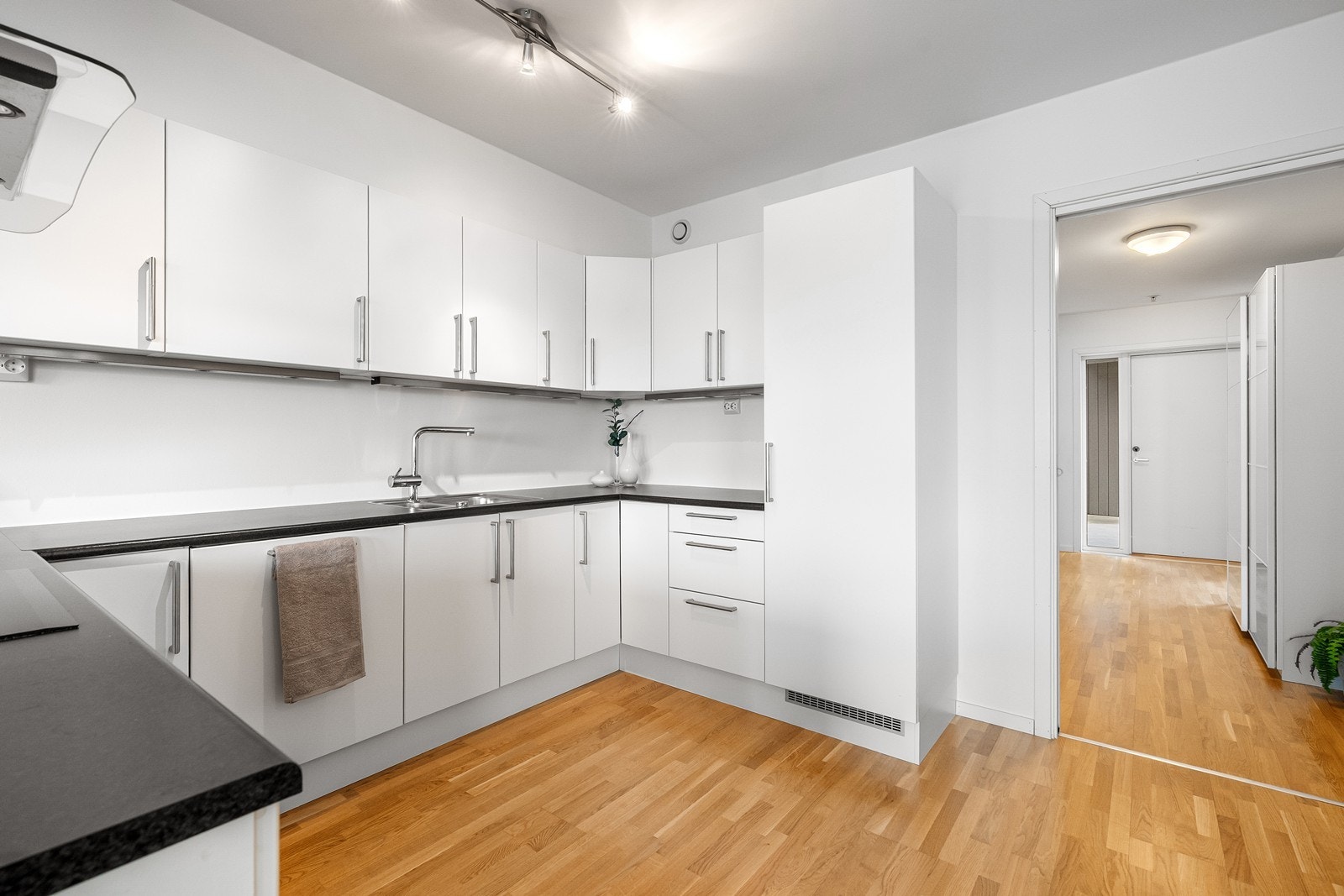 Ett flott kjøkken med belysning under overskap og god benk-/skapplass Galleribilde