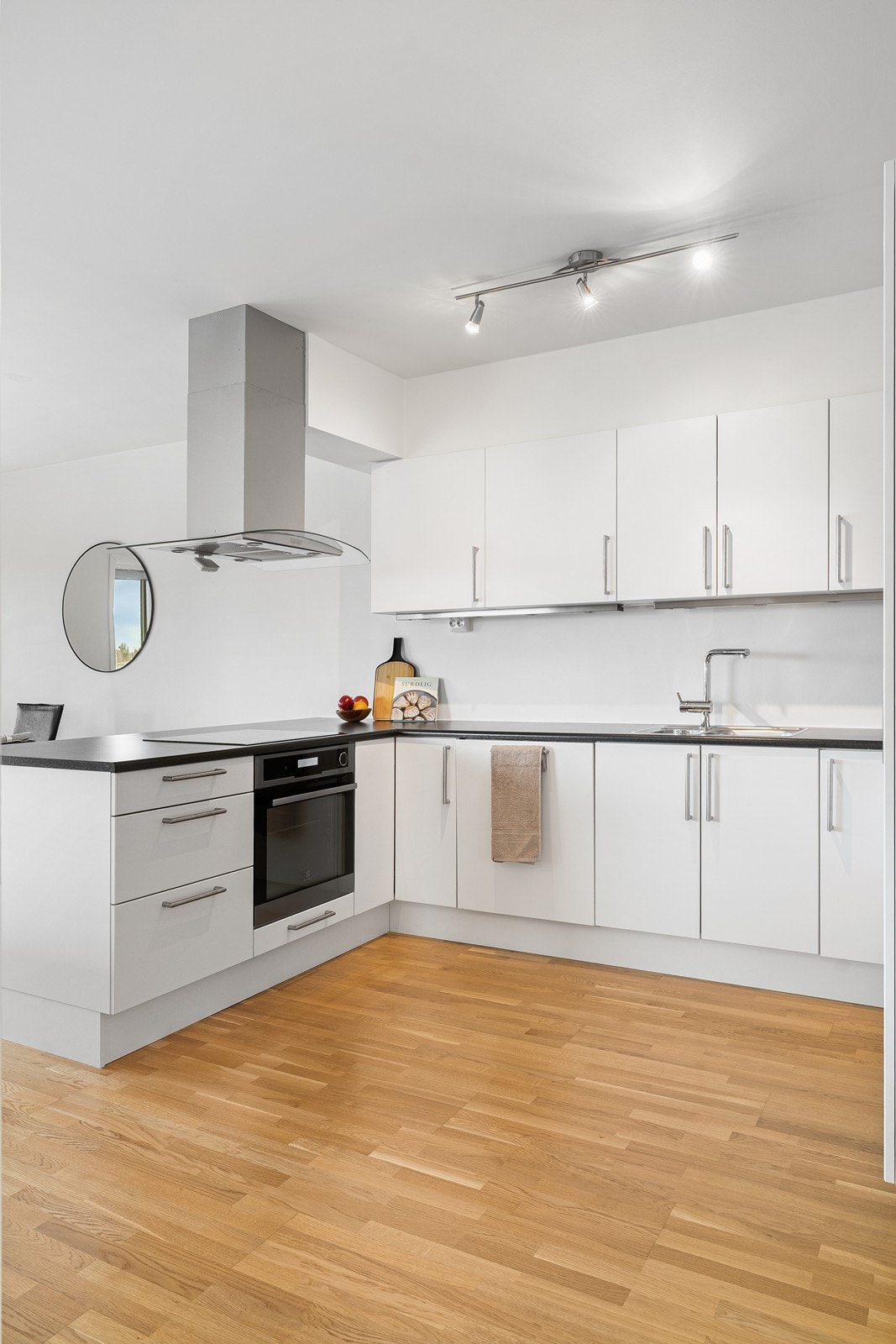 Kjøkkenet har en stilren innredning med glatte fronter og en laminatbenkeplate. Galleribilde