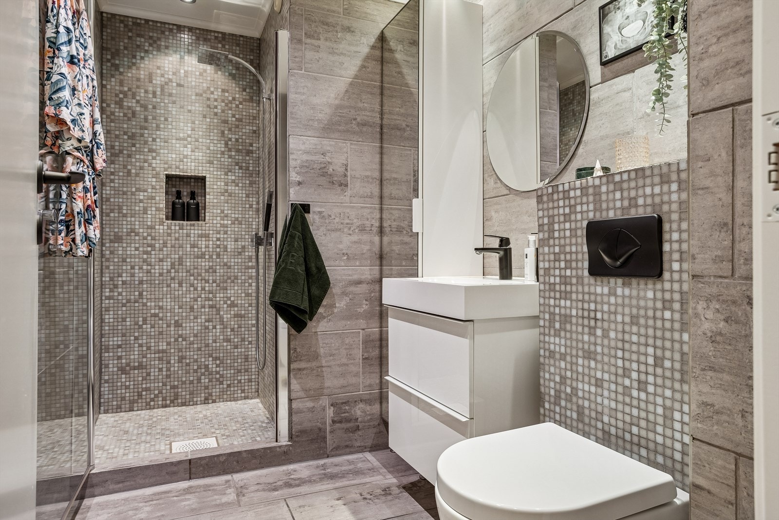 Her er det flislagte overflater, dusjdører i glass og komfortabel varme i gulvet. Galleribilde