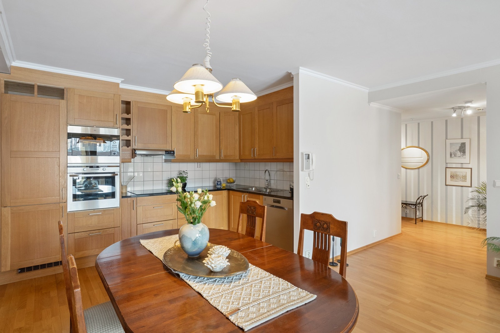 Kjøkkenet har innredning fra byggeår med profilerte fronter og steinplate med nedfelt kum. Kjøkkenet har integrert kjøl/fryseskap, oppvaskmaskin av nyere dato, mikro og stekeovn fra byggeår samt induksjonstopp fra 2023. Galleribilde