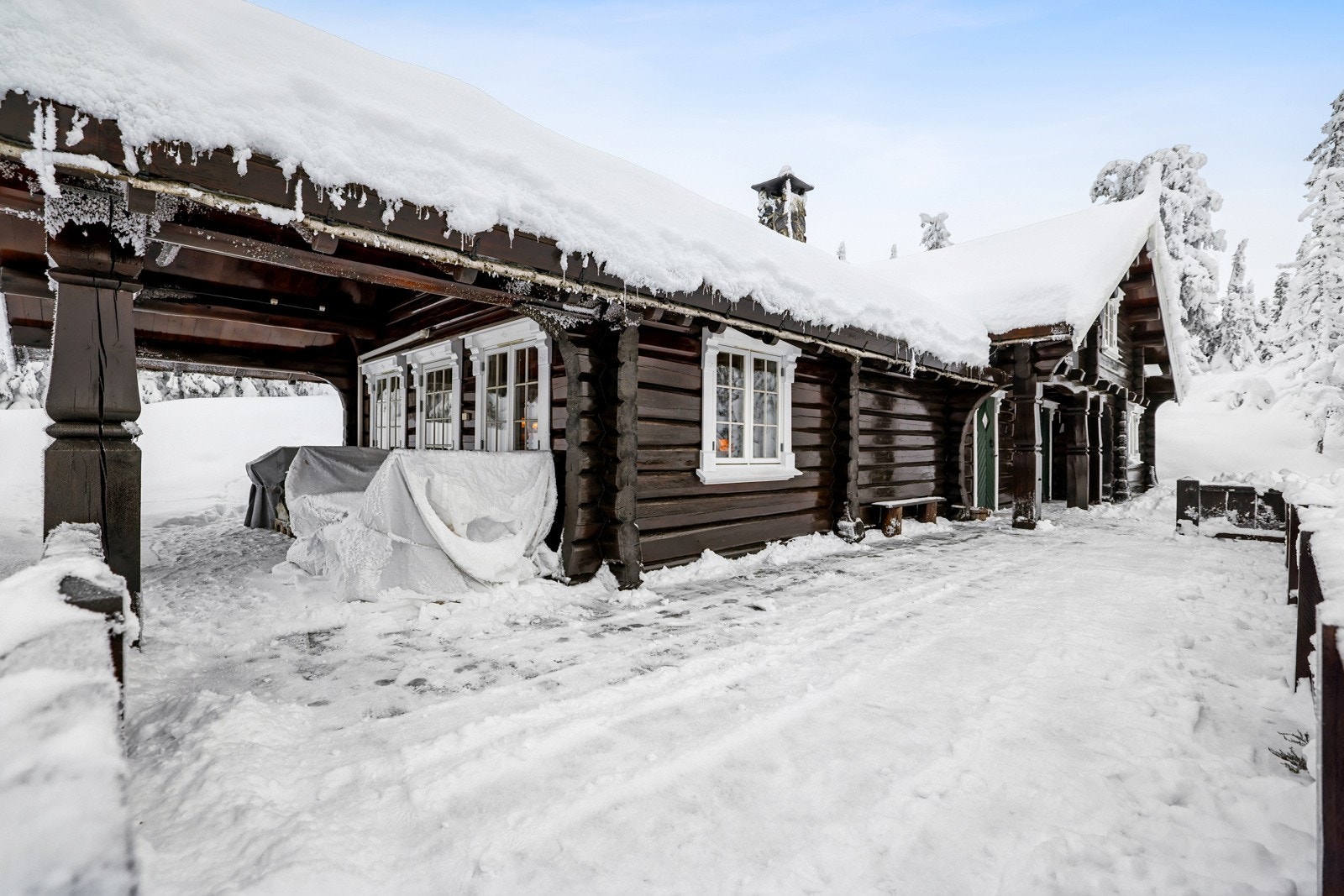 Ved inngangsparti er det skiferfliser på terrasse som strekker seg rundt to sider av hytta. Her ute er det nydelig utsikt og mange muligheter for utemøbler og utekos Galleribilde
