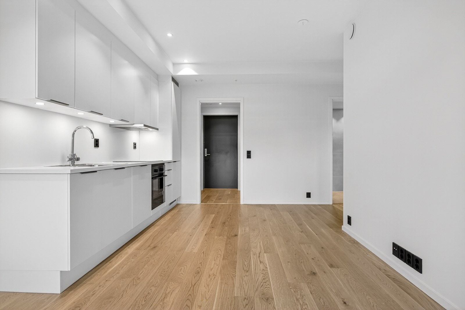 Kjøkkeninnredning med glatte fronter gir et ryddig og moderne uttrykk. Integrerte hvitevarer samler kjøkkensonen. Galleribilde