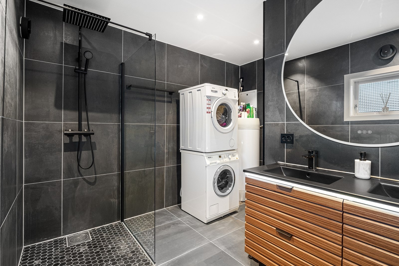 Det inneholder dusjhjørne, vegghengt toalett, dobbel servant med underskap og opplegg til vaskemaskin. Galleribilde