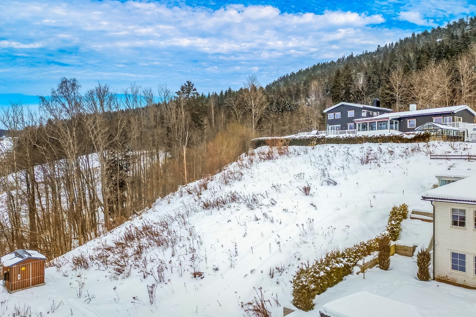 Tomten ligger i et skrående terreng innerst i blindvei. Galleribilde