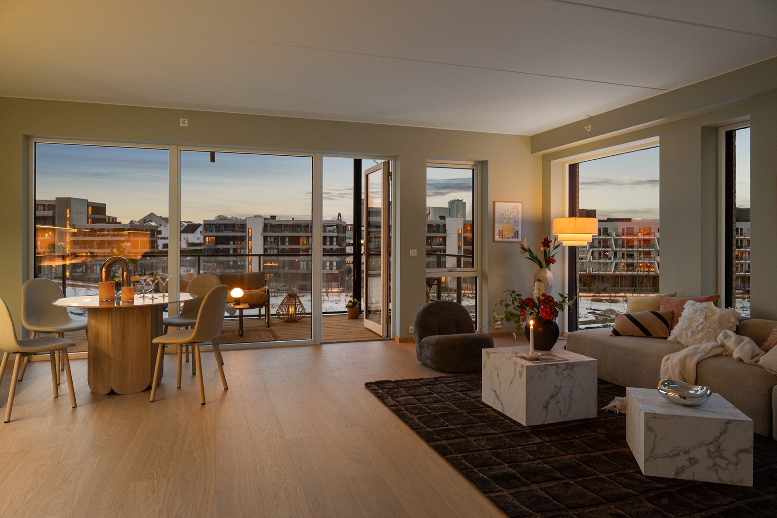 Elegant og lun stue med store vindusflater som slipper inn kveldssolen. Her skapes en varm og eksklusiv atmosfære når solen går ned over området. Galleribilde