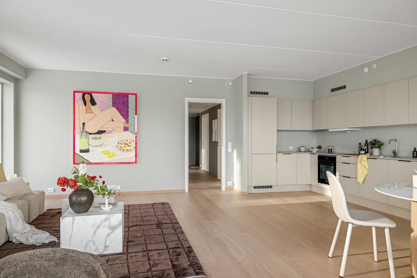 Den åpne løsningen mellom stue og kjøkken skaper en sosial og elegant ramme for både hverdag og gjester. Galleribilde