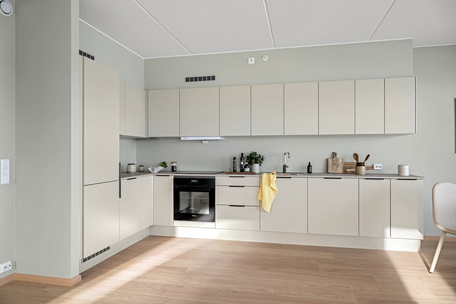 Romslig og gjennomført kjøkken med god skapplass og effektiv arbeidsflyt. Galleribilde