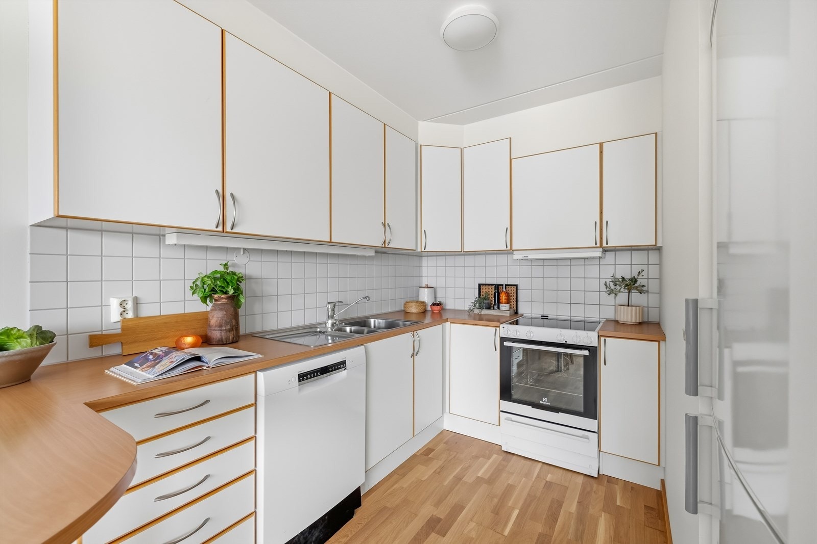 Opplegg for komfyr med platetopp, oppvaskmaskin og frittstående kjøleskap. Galleribilde