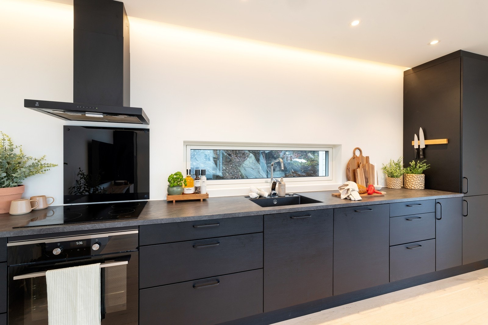 Mørk kjøkkeninnredning med integrerte hvitevarer. Galleribilde