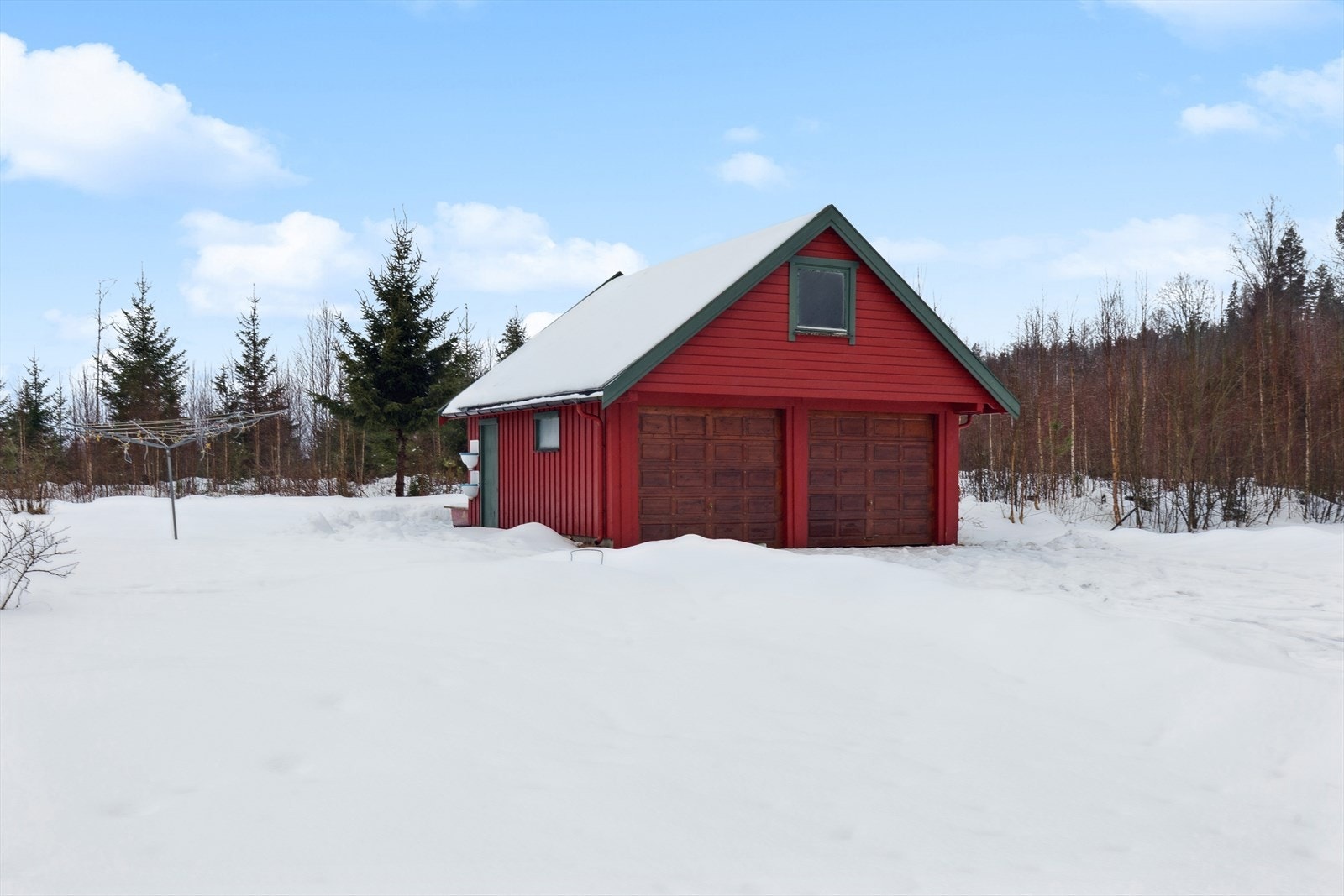 Den frittstående garasjen på 48 m² har to leddporter, bod og et praktisk lagringsloft. Galleribilde