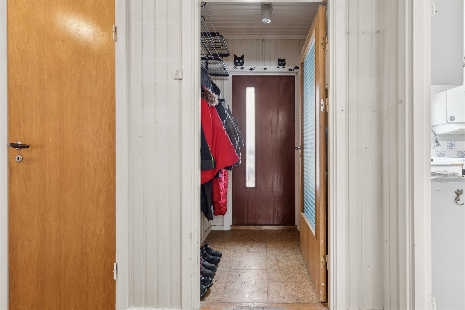 Boligens vindfang har en dør med glassfelt som fører inn til gangen. Galleribilde