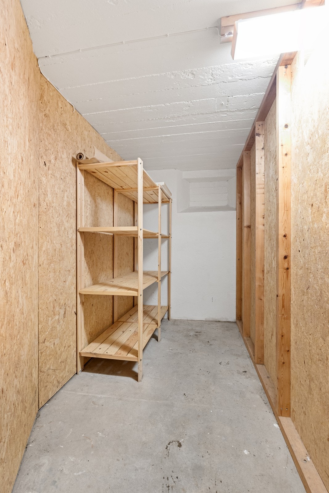 Praktisk bod med betonggulv og trehyller gir god lagringsplass. Galleribilde
