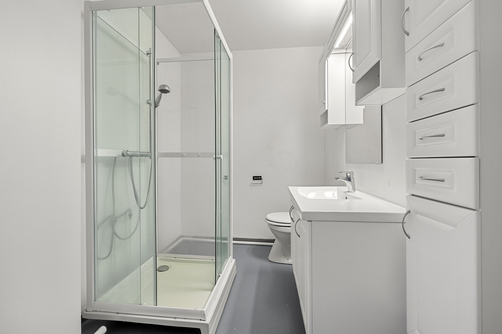 Badet er funksjonelt innredet med dusjkabinett, servant med underskap og høyskap. Galleribilde