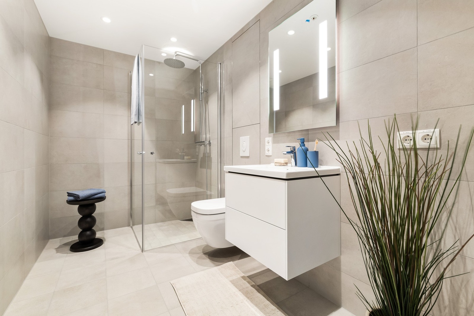 Et stilrent og delikat bad med opplegg til vaskemaskin og tørketrommel Galleribilde