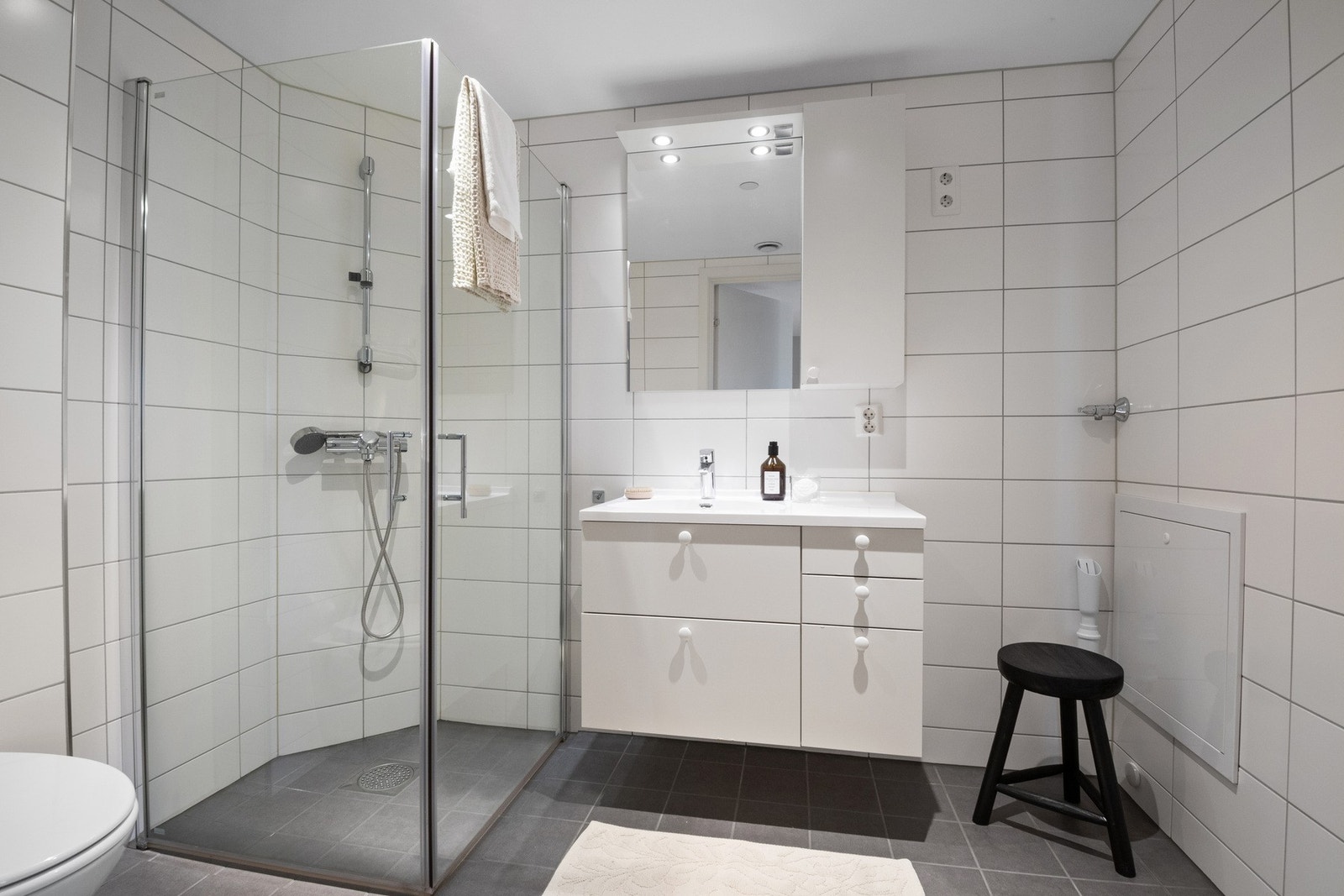 Badet er av god størrelse med dusjnisje, vegghengt toalett, en stor servant med innredning. Galleribilde