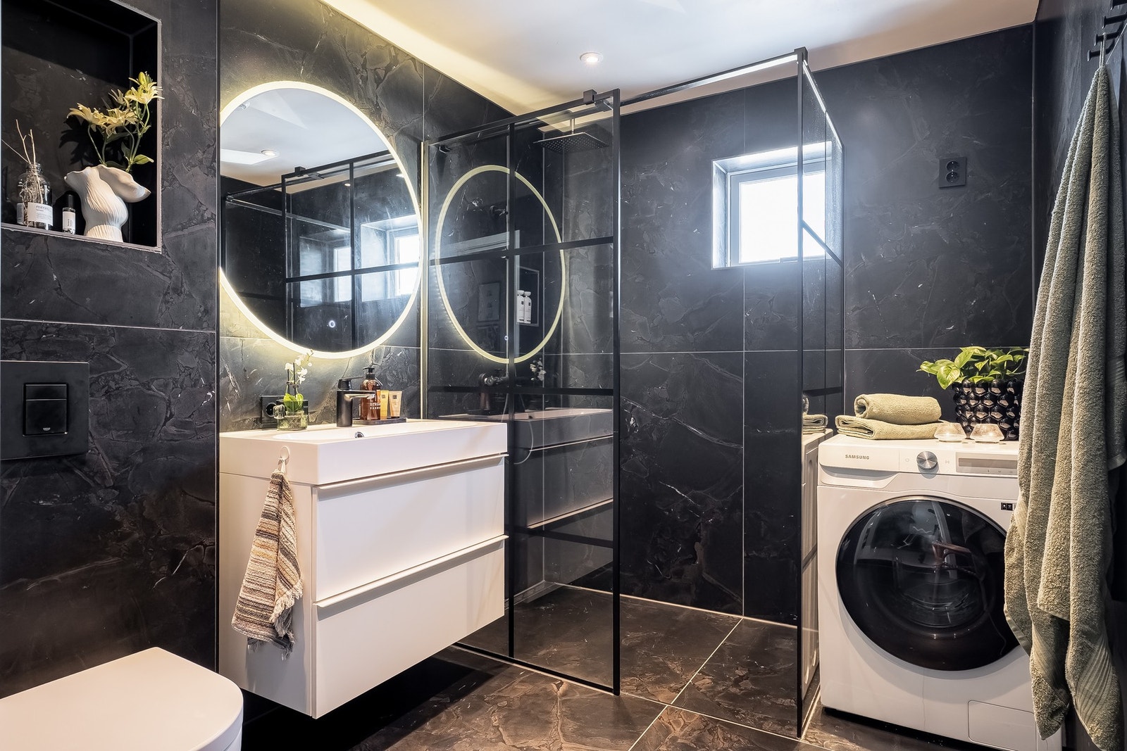 Moderne bad som ble pusset opp i 2021 med mørke fliser, romslig dusj, vaskemaskin og stilfull belysning. Galleribilde