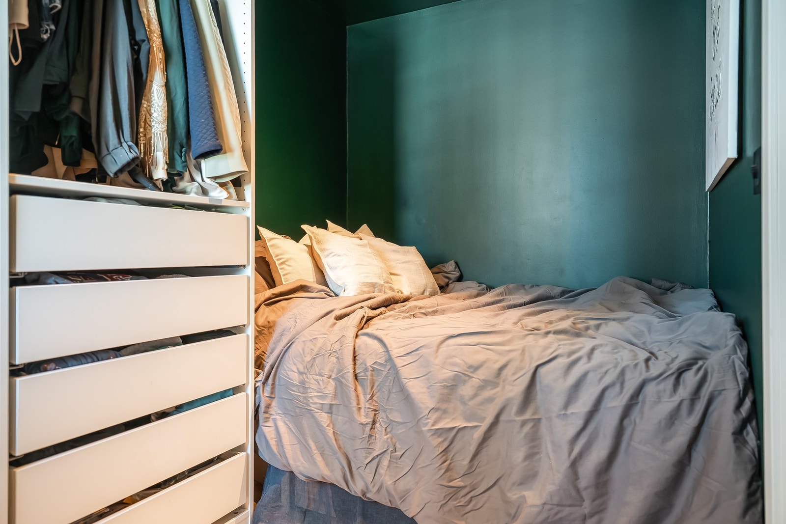 Soverom med mørkegrønne vegger og praktisk garderobeløsning. Galleribilde