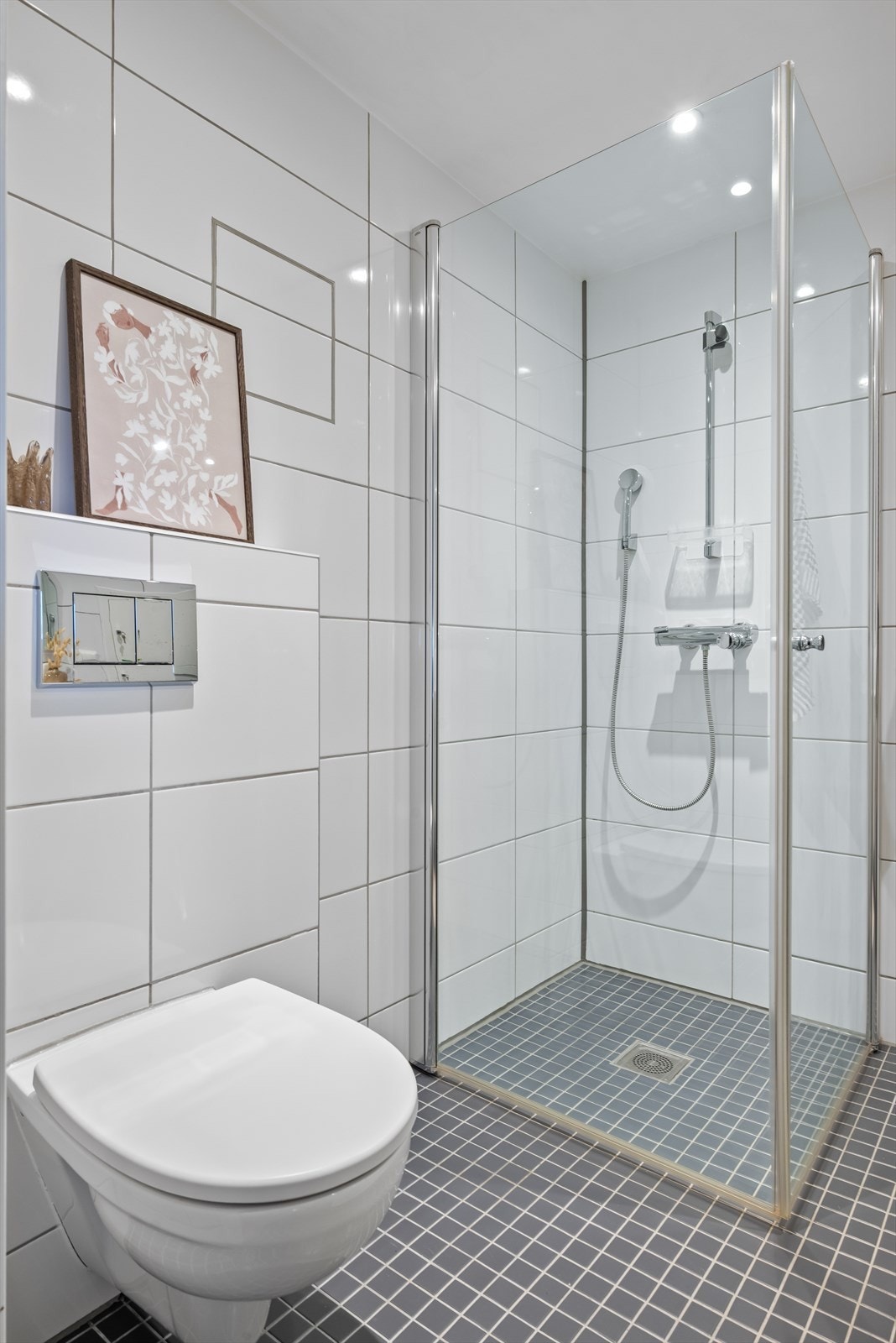 Badet er utstyrt med innfellbare dusjdører, mekanisk avtrekk, toalett, servant i skap, og opplegg for vaskemaskin/tørketrommel. Galleribilde