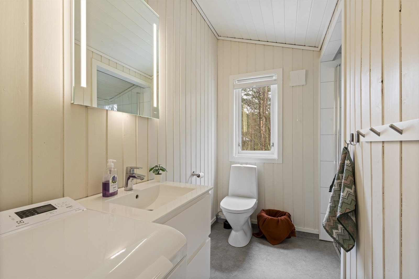 Baderom med servant, toalett, vaskemaskin og dusj Galleribilde