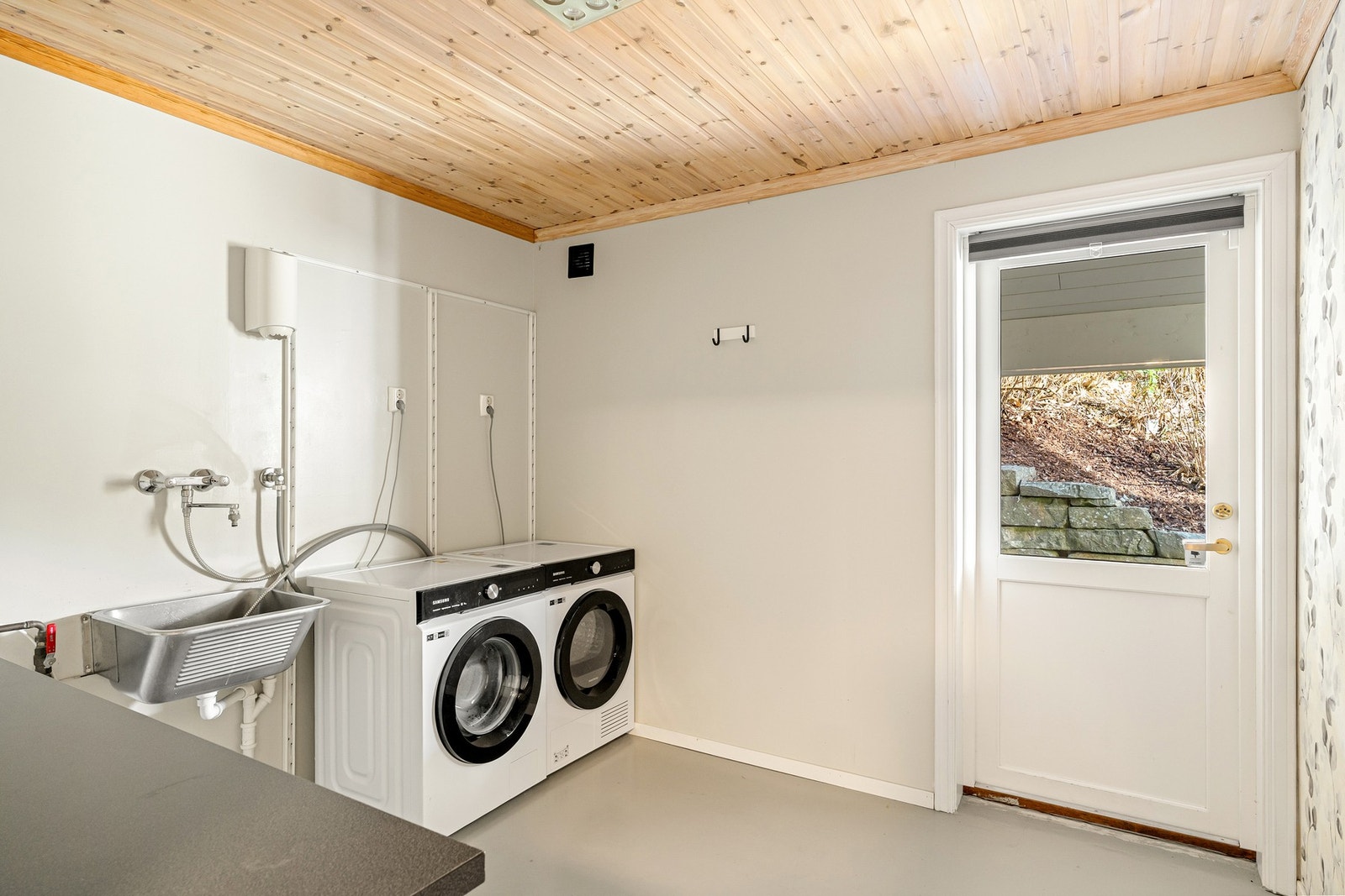 Praktisk biingang/ vaskerom, med opplegg for vaskemaskin, tørketrommel, utslagsvask og benkeplass Galleribilde