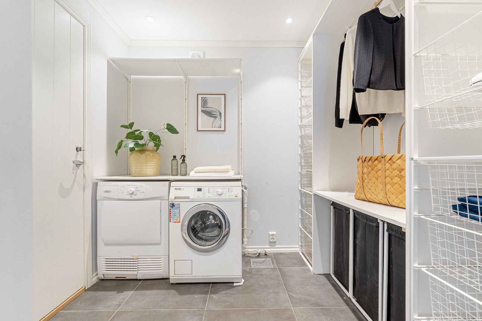 Vaskerommet ligger praktisk til mellom entré og garasje. Flislagt gulv med varmekabler og en gjennomført, ryddig utforming gjør rommet både funksjonelt og behagelig i bruk Galleribilde