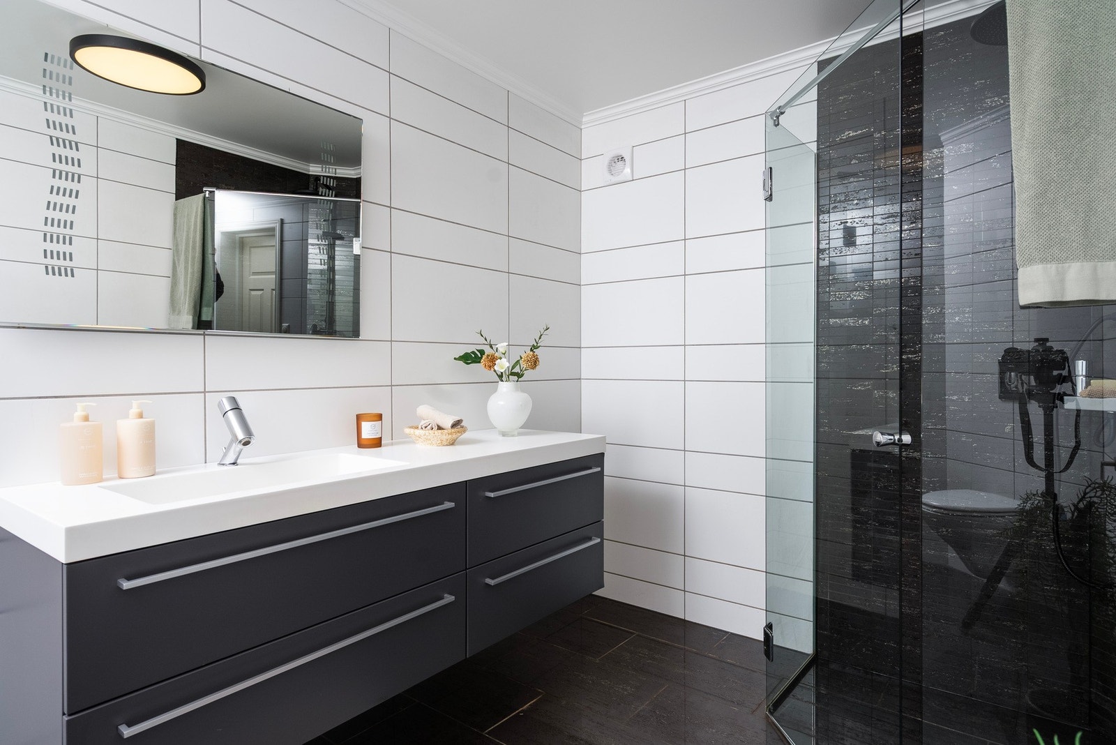 På badet har du flislagt gulv og varmekabler, god oppbevaringsplass i servantinnredning og tidløst fargevalg Galleribilde