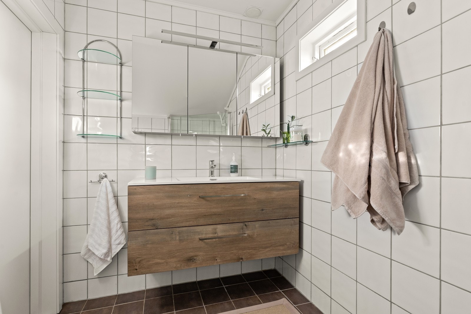 Baderommet i 2. etasje er klassisk flislagt på gulv og vegger. Rommet er utstyrt med moderne servantinnredning med heldekkende servant og skuffer for lagring med slette fronter. Over servanten er det speilskap Galleribilde