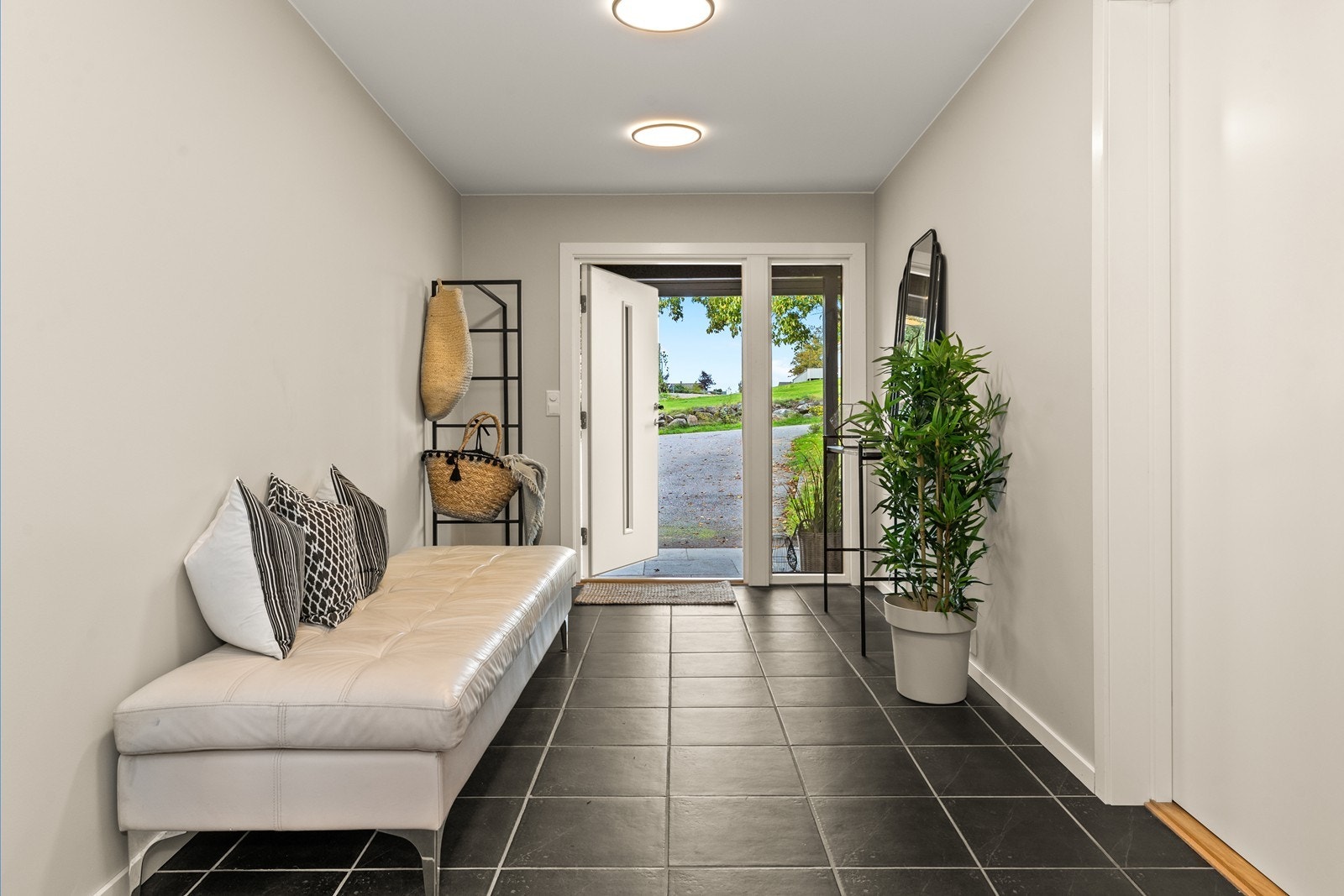 Velkommen inn i den lyse gangen. Mørke fliser på gulvet står i fin kontrast til de øvrige lyse overflatene Galleribilde